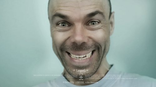 Smiling man with green eyes.